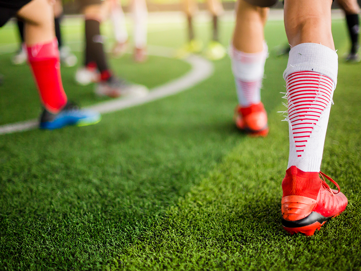 Soccer players standing on artificial grass